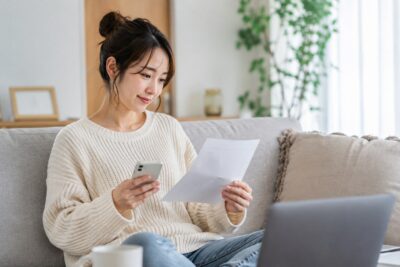 スマートフォンで買取希望の品物を撮影している手元